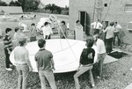 Lindenwood College Students Moving a Satellite Dish on the Roof of Young Hall, circa 1980s by Lindenwood College